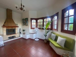 a living room with a green couch and a fireplace at El Álamo, tranquilidad y naturaleza in Teror