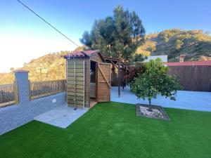 a small garden with a wooden shed and a tree at El Álamo, tranquilidad y naturaleza in Teror