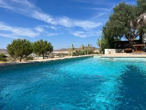 una gran piscina de agua azul en un patio en Luna Moruna, en Los Albaricoques
