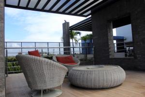 een patio met 2 rieten stoelen en een tafel bij Edf Time, aconchegante e muito bem localizado Apt 1122 in Maceió
