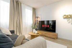 a living room with a couch and a tv at ELLY NINE - stylish urban apartments in Wiesbaden
