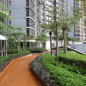 a walkway in the middle of a city with tall buildings at Apartment Goldcoast-Studio Room in Jakarta