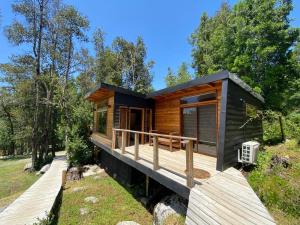 a cabin in the woods with a deck at Cabañas Laderas del estero in Pucón