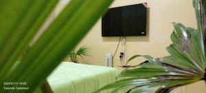a living room with a couch and a flat screen tv at AFRIEUROTEXT Kamerun-High Standing-Appartements-Wifi-Security-Restaurant-modern Kitchen in Yaoundé