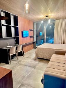 a bedroom with a bed and a desk and a table at Apartamento Beira Mar NEW TIME 1014 in Maceió