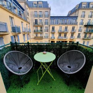 a table and two chairs with a table and a building at Cosy home Disney in Two min in Chessy