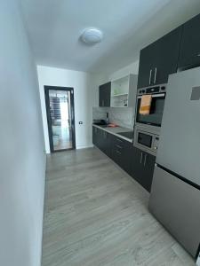 a kitchen with black and white cabinets and a refrigerator at Fuertevida in Caleta De Fuste