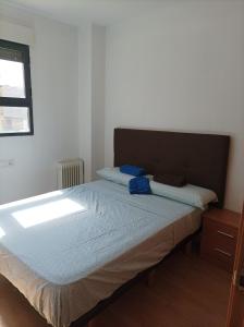 Precioso apartamento a minutos del metro في بيتيرا: غرفة نوم بسرير وملاءات زرقاء ونافذة