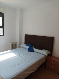 Precioso apartamento a minutos del metro في بيتيرا: غرفة نوم عليها سرير وفوط زرقاء