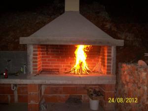 a brick oven with a fire in it at Apartments Hrboka in Žman