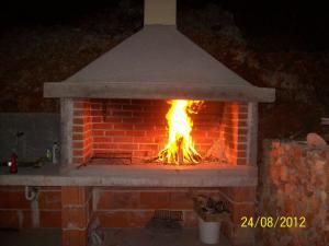 Un horno de ladrillo con fuego. en Apartments Hrboka en Žman