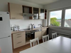 a kitchen with white appliances and a table with chairs at Colleen Homes Monteurwohnung Barntrup Blumenstr 1b in Barntrup