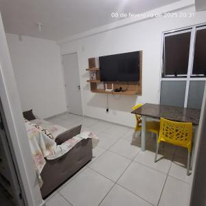 a living room with a couch and a table and a television at Apartamento mobiliado e otima localização in Campina Grande