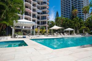 a swimming pool in front of a building at 1BR Tropical Escape with Heated Pools Sauna BBQ in Gold Coast