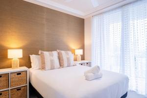a bedroom with two beds and a large window at 1BR Tropical Escape with Heated Pools Sauna BBQ in Gold Coast +20 photos
