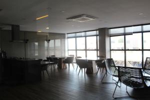 een eetkamer met tafels en stoelen en ramen bij Edf Time, aconchegante e muito bem localizado Apt 1122 in Maceió +27 foto's