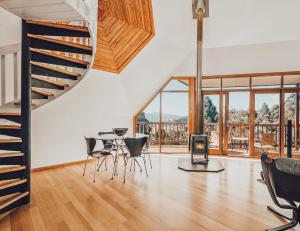 a living room with a staircase and a table and chairs at Forest Hideaway - Silverwood in Franklin