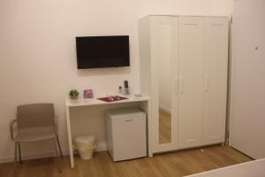 una stanza con una scrivania e una TV a parete di Elegante matrimoniale clemente house catania centro a Catania