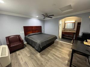 a bedroom with a bed and a chair and a desk at Dutch Motel in Loma Linda