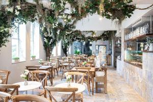 a restaurant with tables and chairs and plants at 2-Min to Beach, Upscale Enclave in Miami Beach
