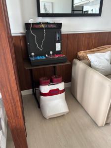 a bedroom with a bed and a tv and a couch at La Rynaz - Azure North in Pampang