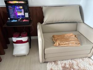 a room with a chair next to a table with a laptop at La Rynaz - Azure North in Pampang