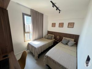 ein Hotelzimmer mit zwei Betten und einem Fenster in der Unterkunft Pôr do Sol na Barra I in Salvador + 55 Fotos