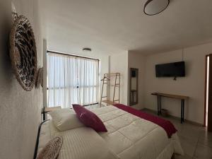 a bedroom with a bed and a television on the wall at Estancias HGS in Santiaguito