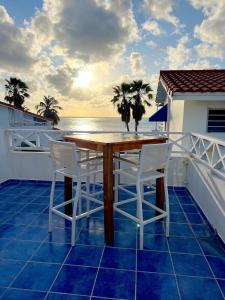 una mesa de madera y sillas en un balcón con vistas al océano en Paradise for two on the Caribbean Sea, en Sabana Westpunt