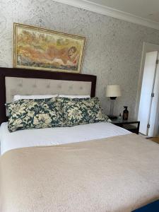 a bedroom with a bed and a painting on the wall at casa bela in Lauro de Freitas