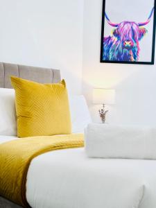 a bedroom with a bed with a yellow blanket at Luxury City Centre Apartment in Edinburgh
