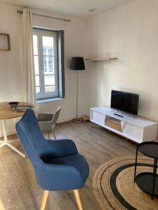 a living room with a blue chair and a tv at Studio centre proche marché et RER avec wifi in Saint-Germain-en-Laye