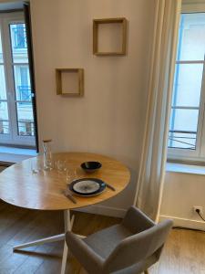 a dining room table with a bowl and glasses on it at Studio centre proche marché et RER avec wifi in Saint-Germain-en-Laye