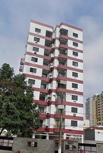 un edificio alto blanco y rojo en una ciudad en Ap Canto do Forte com Wi-Fi, TV e varanda, en Praia Grande