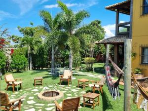 a patio with chairs and a fire pit in a yard at Casa Amarela Praia Grande in Fundão
