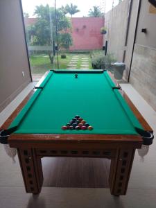 a green pool table with balls on top of it at Casa Amarela Praia Grande in Fundão