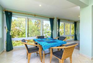 a dining room with a table and chairs and windows at The Tree House Bella Seaview Diani Beach Kenya in Diani Beach +52 photos