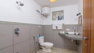 a bathroom with a toilet and a sink at The Tree House Bella Seaview Diani Beach Kenya in Diani Beach