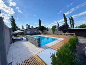 een zwembad in een achtertuin met een houten terras bij Cabañas Golden in San Rafael