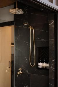 a shower in a bathroom with a black wall at SHAK Halls Gap - Off Grid Tiny Home in Halls Gap