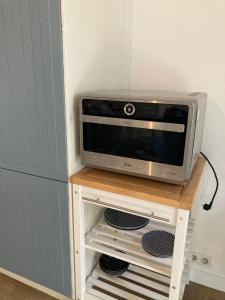 a microwave on a table next to a refrigerator at Studio centre proche marché et RER avec wifi in Saint-Germain-en-Laye +2 photos