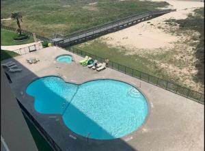 an overhead view of two swimming pools on the beach at SPI FUN! - Beach View - 2025 Full Remodel - 2BR Condo OV502 in South Padre Island