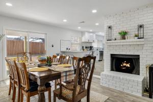 a kitchen and dining room with a table and a fireplace at Frisco Getaway Hometel w the Spa and Outdoor Kitchen in Frisco