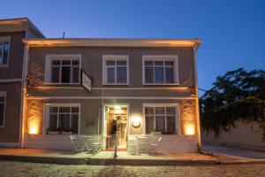 a building with tables and chairs in front of it at LİME BOZCAADA in Bozcaada