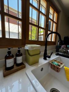 a kitchen sink with two bottles on a counter at Hermosa casa en Barrio Pocuro con estacionamiento gratuito in Santiago