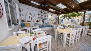 a restaurant with white tables and white chairs at LİME BOZCAADA in Bozcaada