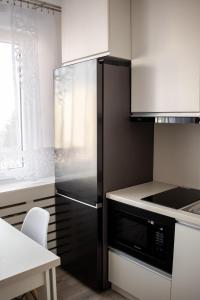 a kitchen with a stainless steel refrigerator and a table at MyPlace Caramel Apartment Sandomierz in Sandomierz
