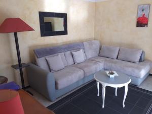 a living room with a couch and a table at Rez-de-jardin 50 m² entre Biarritz et Capbreton in Ondres