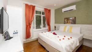 a bedroom with a large white bed with flowers on it at LİME BOZCAADA in Bozcaada