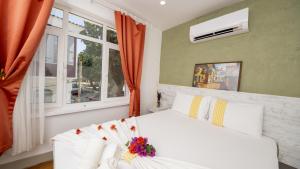 a bedroom with a white bed and windows at LİME BOZCAADA in Bozcaada